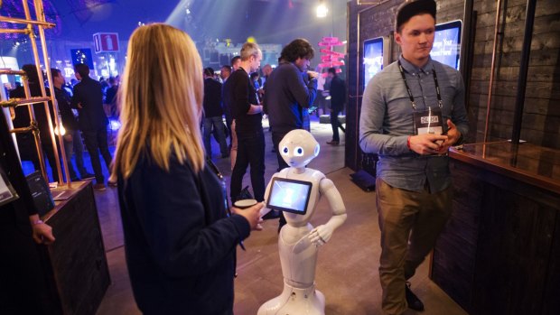 Pepper the humanoid robot interacts with an attendee at Slush 2016.