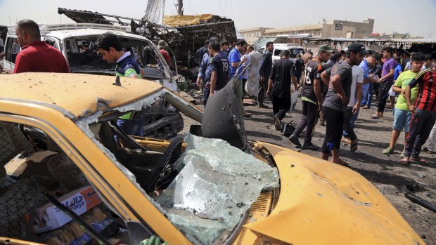 Citizens inspect the scene of a suicide car bomb which hit a crowded outdoor market in Baghdad's eastern Shiite neighborhood of Sadr City on Tuesday.