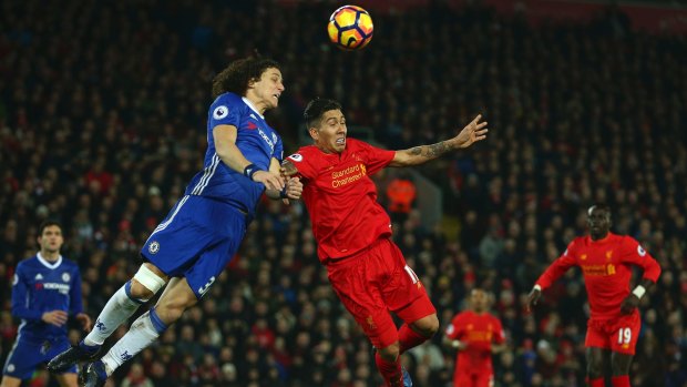 Chelsea's David Luiz, left, competes for the ball with Liverpool's Roberto Firmino.