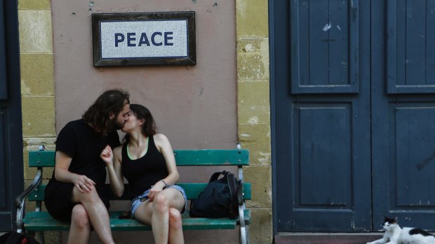 Oblivious: A couple kiss at the  crossing point that connects the Greek Cypriot south to the Turkish Cypriot north in Nicosia.