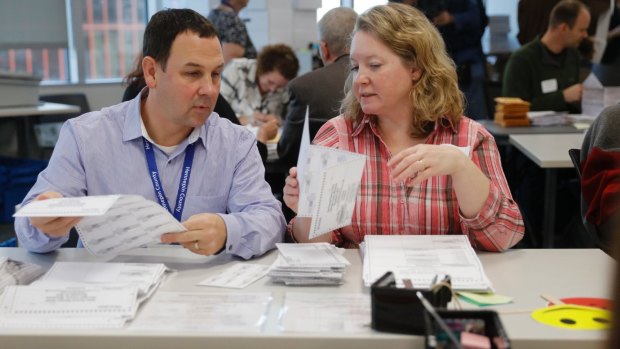 Election workers flatten ballots so they can be fed through the counting machines in Minneapolis. 