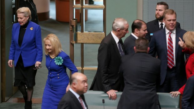 Former speaker Bronwyn Bishop enters the chamber while Tony Smith is congratulated by colleagues in the House of Representatives following his selection as her replacement.