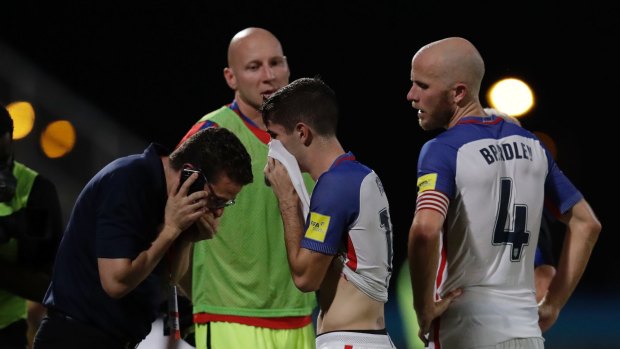 Christian Pulisic, centre, and Michael Bradley, walk off the pitch after the loss.