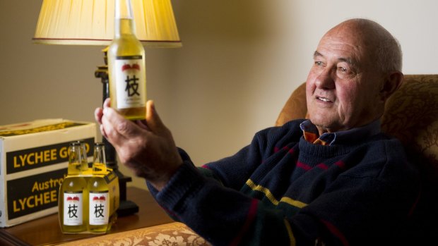 Alan Aston surveys a bottle of his Lychee Gold Cider. 
 