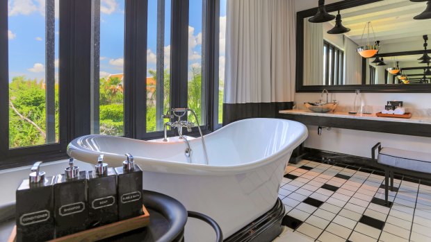 A bathroom, featuring a classic, deep bathtub, in the Siam Suite.