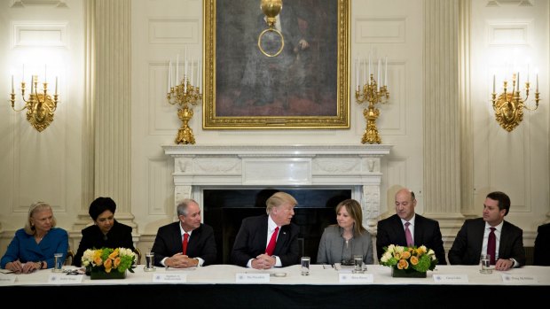 Happier days: Donald Trump meets with business leaders at the White House. Almost all have now abandoned him.