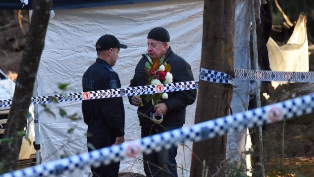 Mark Leveson holds flowers at the crime scene.
