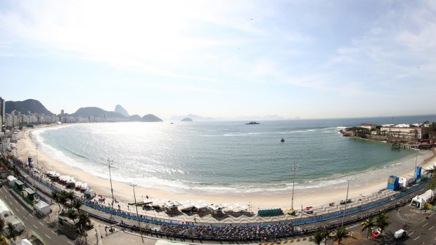 The peloton rides through Copacabana beach during the Men's Road Race on Day 1 - the fort visible on the right. 