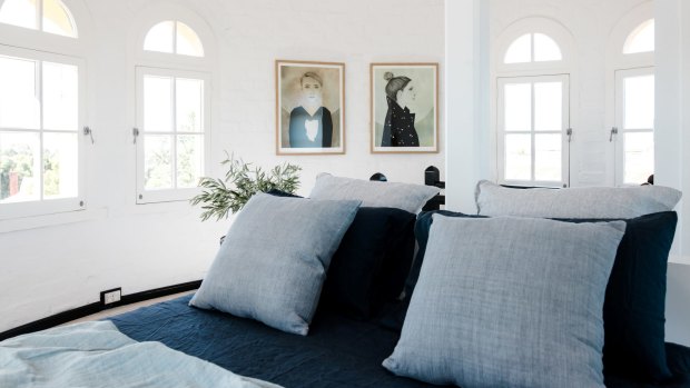 A steep black spiral staircase leads to the bedroom and bathroom at the top.