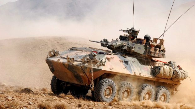 An Australian Light Armoured Vehicle gathers dust as it climbs a feature north of Tarin Kowt.