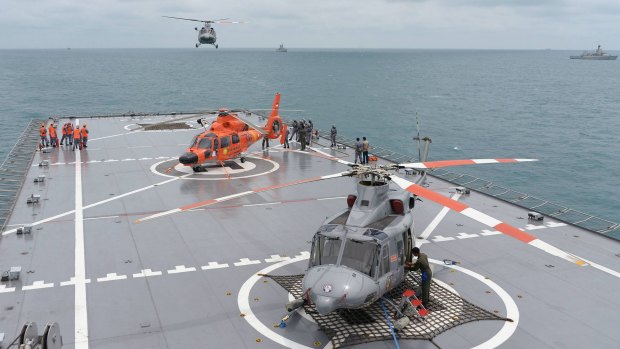 A navy helicopter arrives at the KRI Banda Aceh, near the area where the tail of AirAsia QZ8501 was found in the Java Sea.