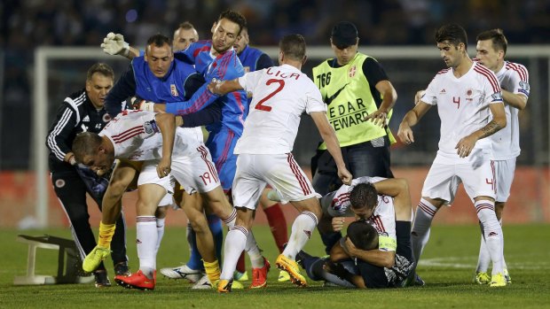 Fans and players clash on the pitch.