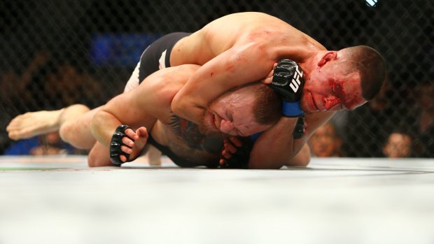 Nate Diaz applies a choke hold to win by submission against Conor McGregor.