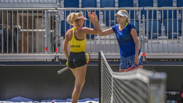Marta Kostyuk (yellow top) and Nadia Kichenok training in Canberra ahead of their Fed Cup tie against Australia. 