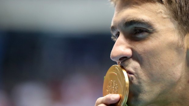 Michael Phelps celebrates with his gold medal after the men's 200m butterfly.