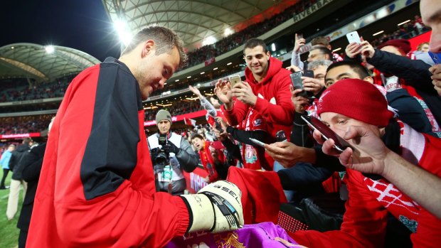 Liverpool goalkeeper Simon Mignolet signs autographs after the match.