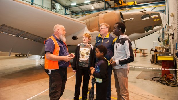 The Treloar Technology Centre conservator Reverend Woody chats with Jim and Isaac, 12, Phillis of Gordon and David and Elya, 6, Okunyah of Casey about Big Things in Store