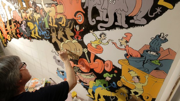 John Simpson, project director of exhibitions for the Amazing World of Dr Seuss Museum, paints a mural based on artwork in the book <I>Did I Ever Tell You How Lucky You Are?</I> 