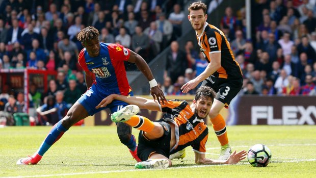 Crystal Palace's Wilfried Zaha, left and Hull City's Andrea Ranocchia challenge for the ball.