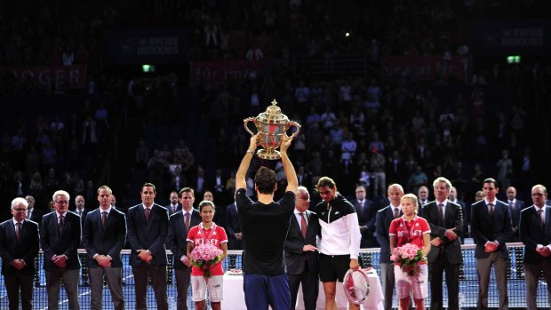 Roger Federer holds up the trophy.