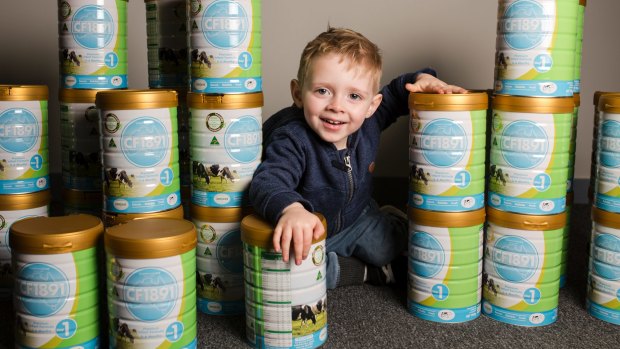 Two-year-old Jack Davey with some of the almost $200,000 worth of baby formula which will help Canberra families in need.