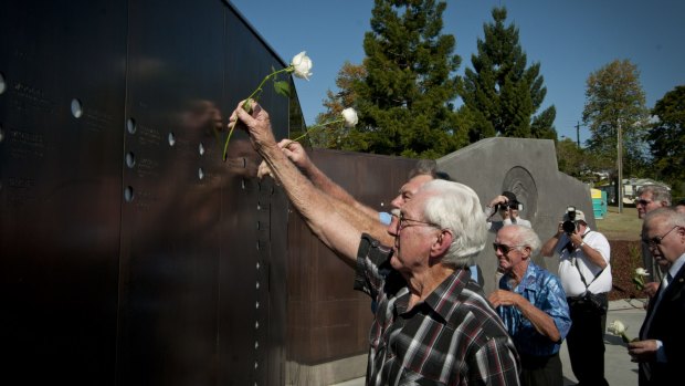 Retired miners placing flowers into the memorial holes in memory of their fallen comrades.