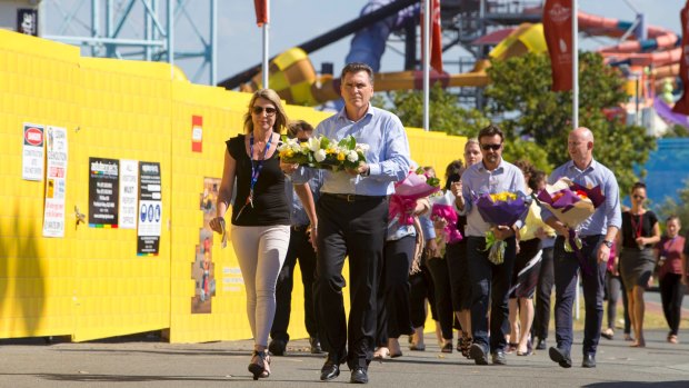 Dreamworld chief executive Craig Davidson and his employees leave flowers at the site on Wednesday.