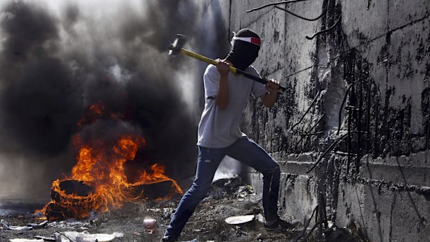 Unrest: A Palestinian student tries to break the separation barrier between the West Bank and Israel.