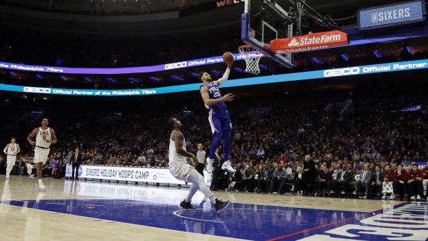 Philadelphia's Ben Simmons goes up for a dunk above Cleveland's JR Smith.