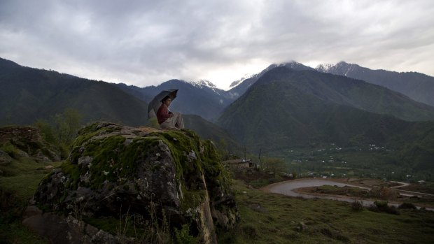 Sarvar Ahmed, a young Kashmiri shepherd, sits on a rock in the outskirts of Srinagar in Indian-controlled Kashmir on Thursday.