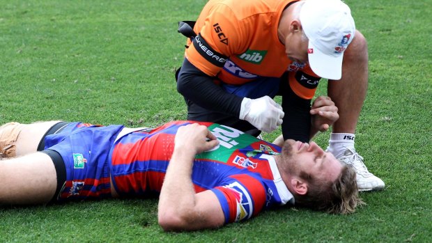 Head knock: Brendan Elliot is treated during the round three match between the Knights and Rabbitohs.
