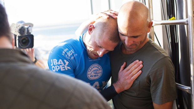 Glad you're all right: Kelly Slater embraces fellow world champion Mick Fanning after the Australian surfer's shark attack.