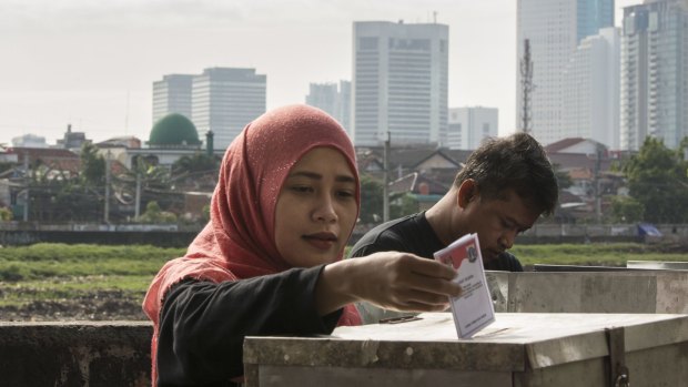 A woman casts her ballot in the election for Jakarta's governor on Wednesday.