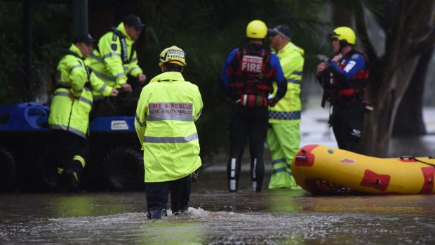 Fire crews with an inflatable boat talk to police during flooding at Raymond Terrace on Wednesday.