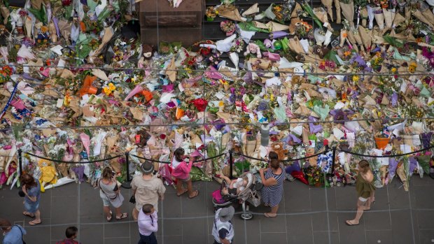 People lay flowers at the memorial to the victims in the wake of the Bourke Street attack.