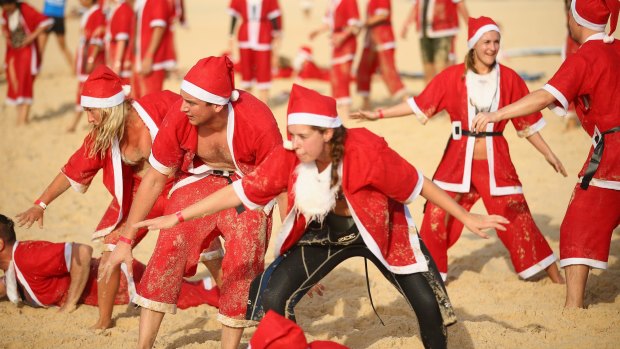 Participants dressed as santa take part in a world record attempt for the world's largest surf lesson at Bondi Beach.