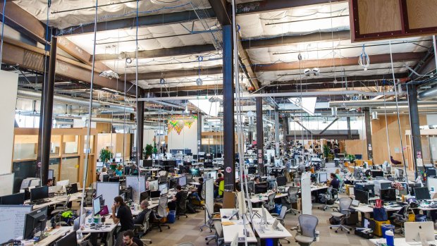 Employees can be seen inside Facebook's main building, the largest open-office workspace in the world. Chief executive Mark Zuckerberg's desk is exactly like all the others.