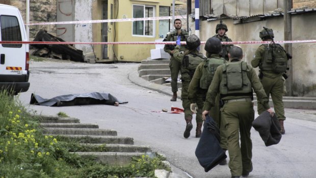Israeli soldiers near the body of a Palestinian who was shot and killed by a soldier in March. 