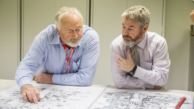 Artist Jim Kaucz, left, and head of military heraldry and technology at the Australian War Memorial Nick Fletcher look at the progress of Mr Kaucz's Anzac illustration.
