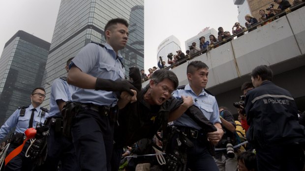 Final act of defiance: A protester is carried away by police officers outside government headquarters in Hong Kong on Thursday.