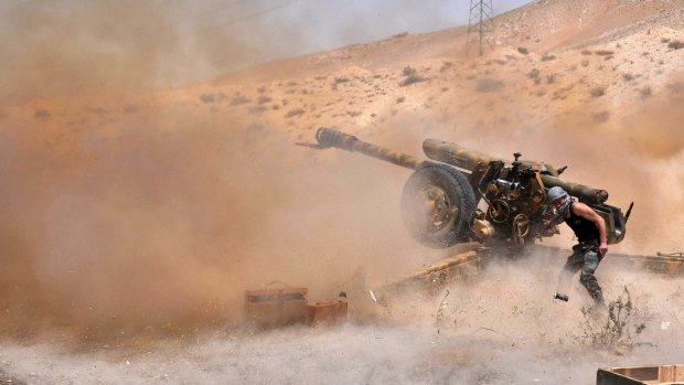 A Syrian army soldier fires artillery shells towards Islamic State  in north-eastern Palmyra.