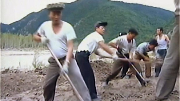In this undated image from video distributed on  September 12, 2016 by North Korean broadcaster KRT, North Korean workers build levees along a river bank. North Korea is mobilising to deal with a disastrous flood.