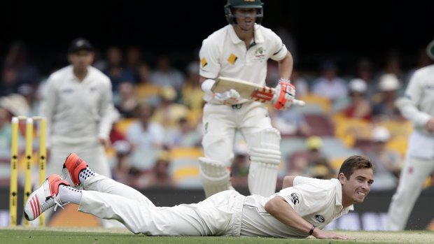 New Zealand's Tim Southee dives in vain as Australia's Joe Burns plays a shot past the bowler.