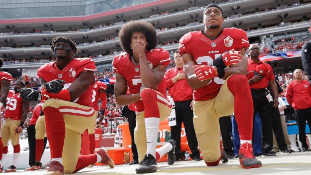 Protest: Eli Harold, Colin Kaepernick and safety Reid kneel during the national anthem.