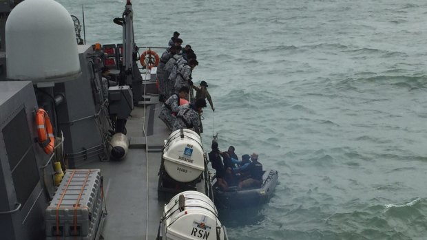 An Indonesian Navy seaboat picks up AirAsia debris retrieved by the Republic of Singapore Navy vessel RSS Valour. 