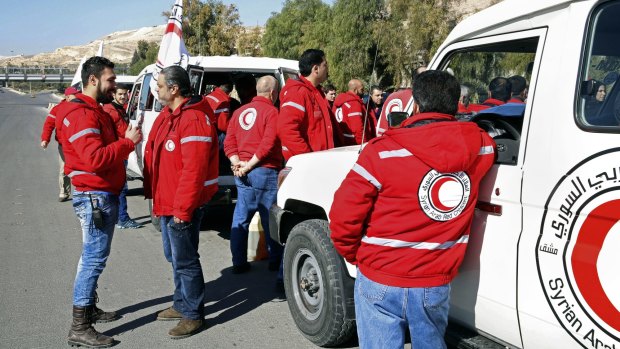 Syrian Arab Red Crescent staff get ready to accompany an aid convoy into rebel-held towns in the Damascus countryside.