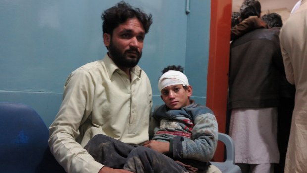 A Pakistani man holding his son as they wait for medical help at a local hospital in Mingora, Pakistan.