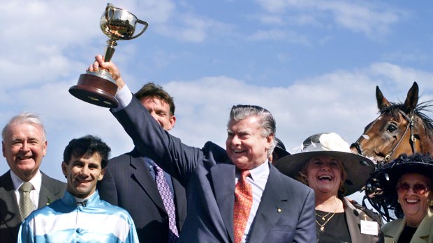 Trainer Bart Cummings lifts the Melbourne Cup after Rogan Josh claimed the 1999 Melbourne Cup. The horse's colourful owner, Wendy Green, a Cup tour "ambassador", is second from right. 