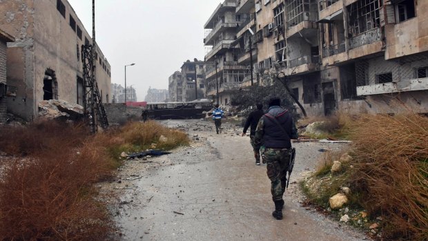 Syrian troops and pro-government gunmen marching through the streets of east Aleppo on Tuesday. 
