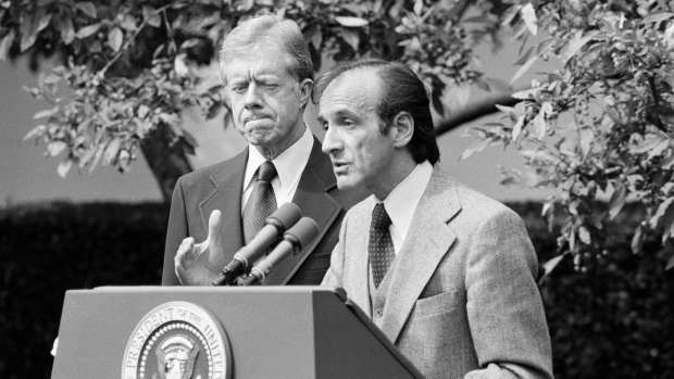 President Jimmy Carter standing by as Elie Wiesel, chairman of the president's Holocaust committee speaks in the White House Rose Garden in 1979.